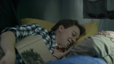 A man and woman lay together in a tent