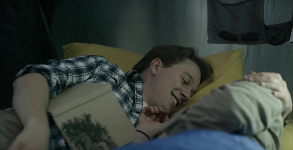 A man and woman lay together in a tent