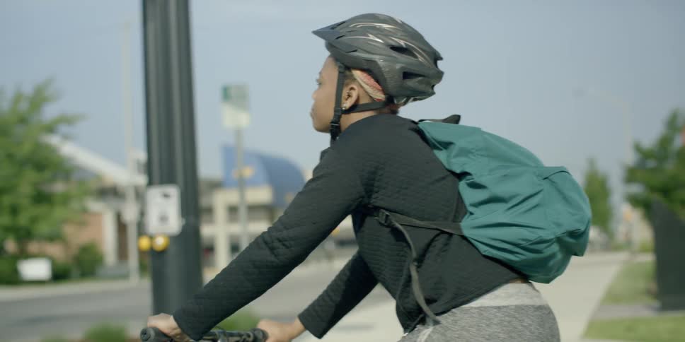 A woman waits on her bike for the cross light to change