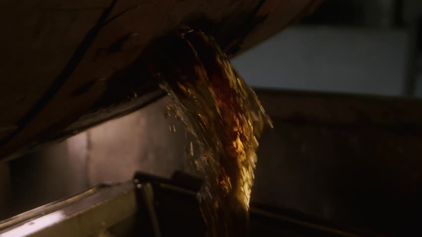 Oil being poured in to a fryer in a restaurant