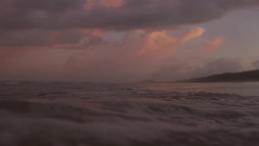 The sun is setting on the ocean