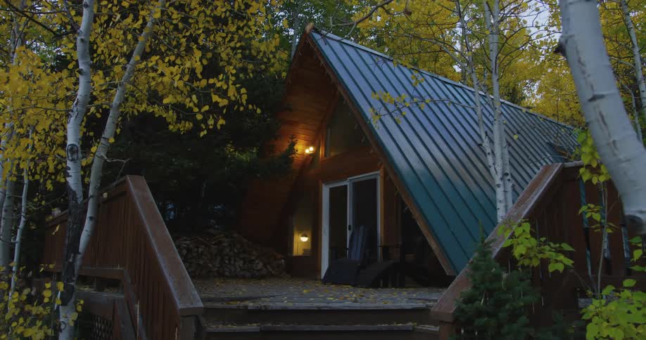 An exterior light comes on at a cabin in the woods