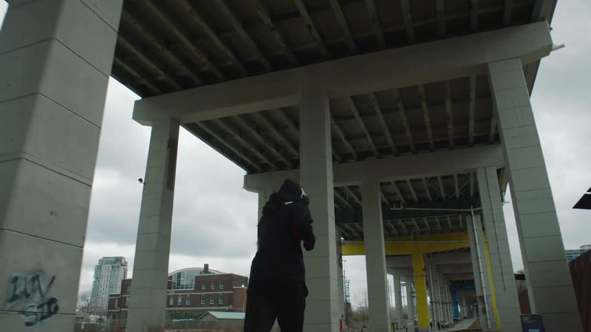 A man is jogging under the overpass