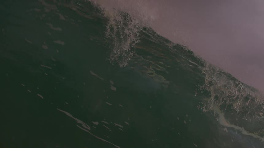 A large wave falls in the ocean