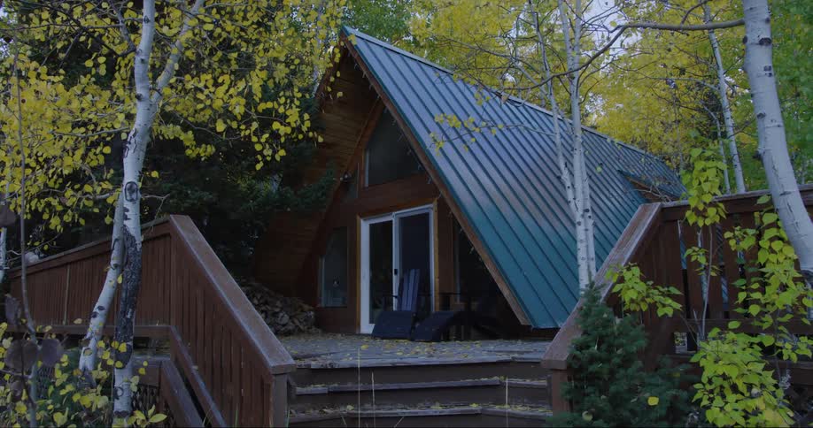 A home in a rural area with trees with fall leaves surrounding it