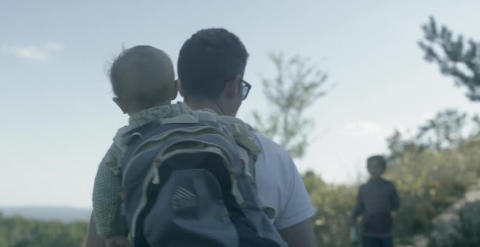 A dad walks with his children up a mountain path