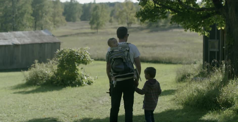 Father and sons hiking through a farm