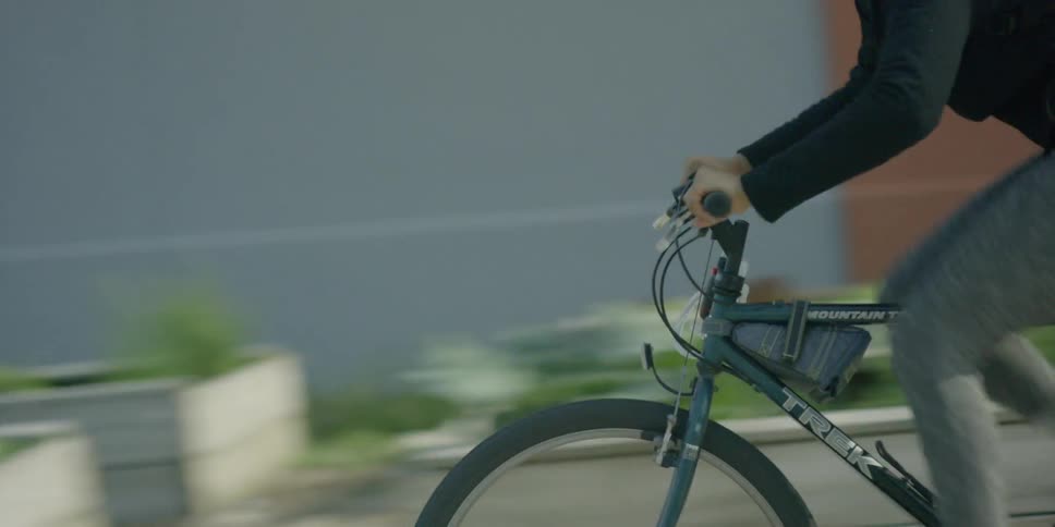 A woman wearing a bike helmet rides her bike on a sunny day