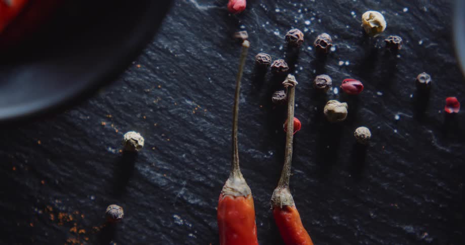 Pepper corns and red peppers are on the table
