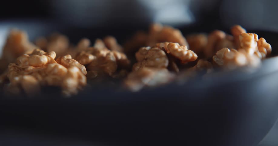 Shelled walnuts spill out of a bowl