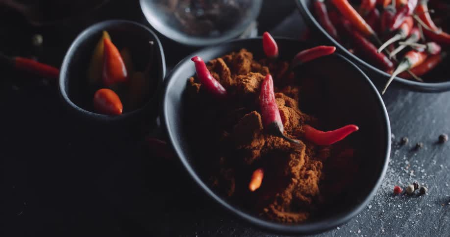 The bowls are filled with peppers and spices