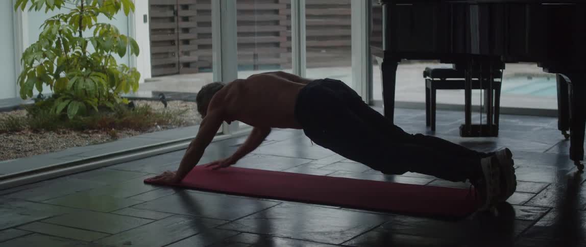 A man is on the floor doing push ups on an exercise mat