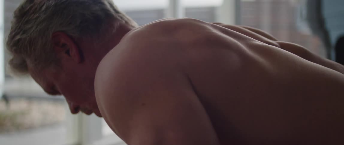 Older bare chested man works out