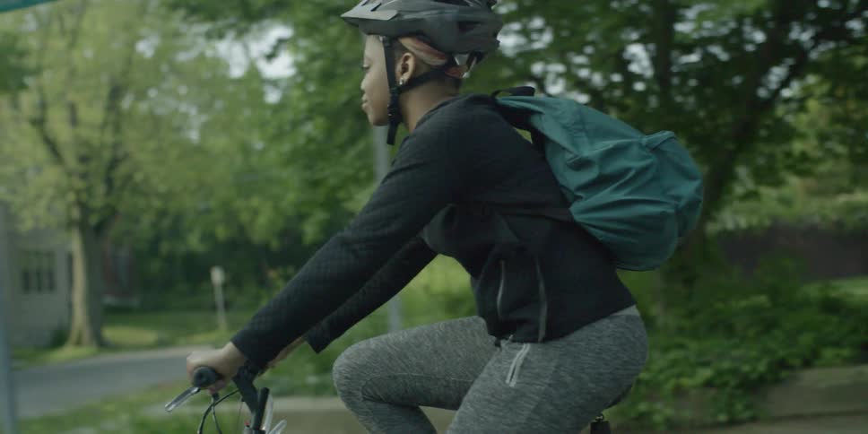 A woman bikes down the street
