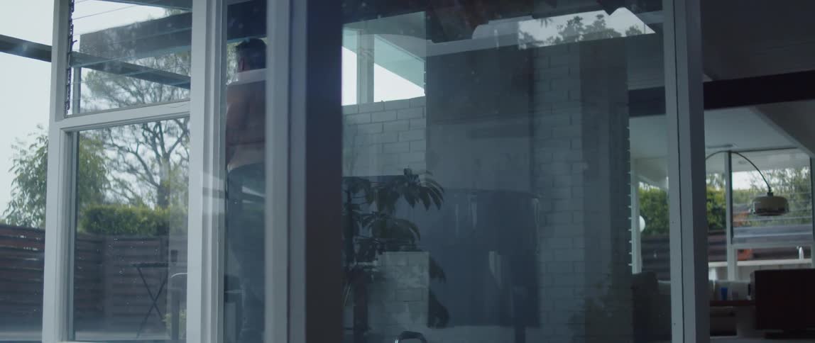 A man is working out in his house near a window