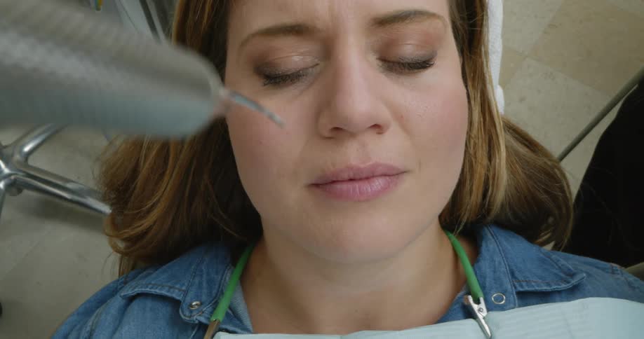 A dental patient opens her mouth for an examination