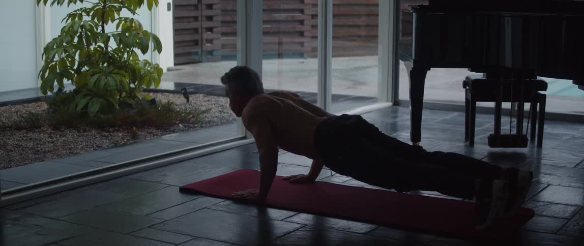 A man is doing yoga inside of his home