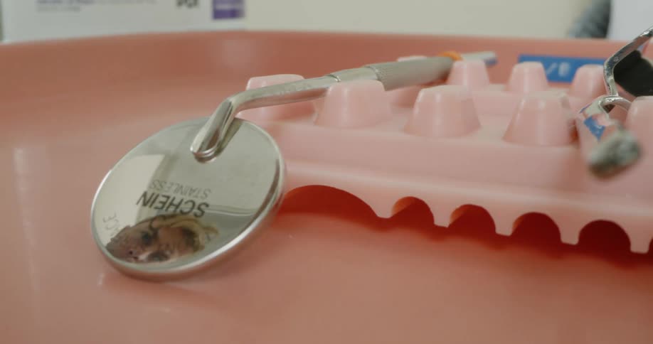 A person places medical instruments on a tray