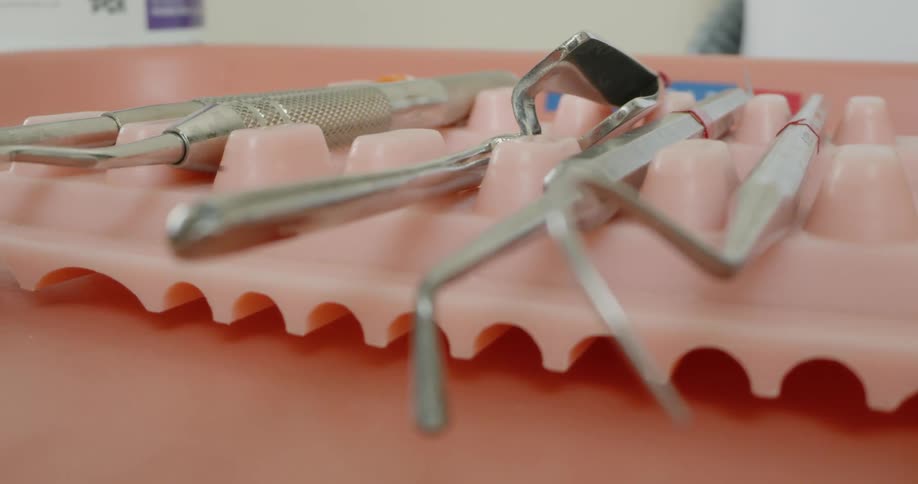 A person in a dental clinic picks up a dental tool
