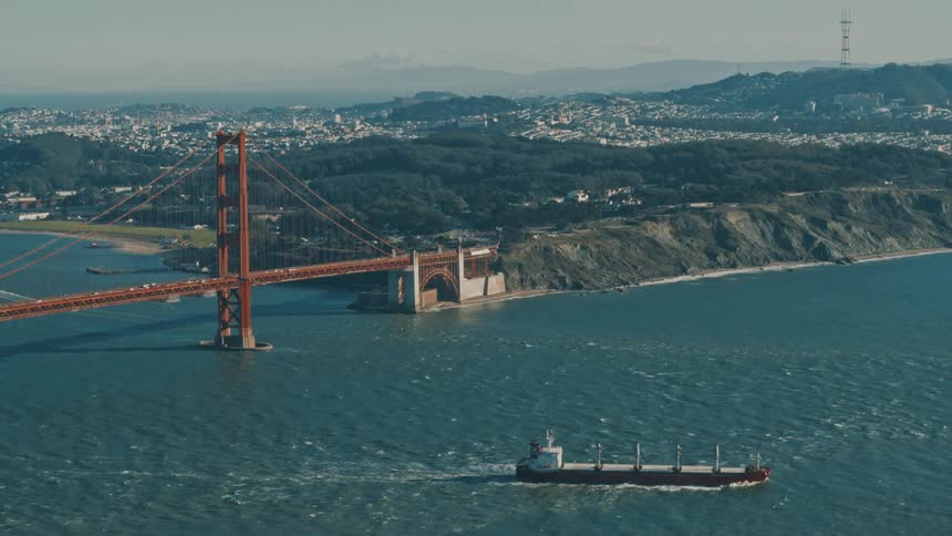 A cargo shipping sails near the golden gate bridge