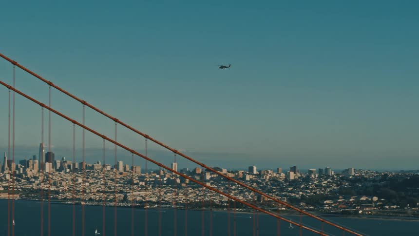 A helicopter flies over the Golden Gate Bridge