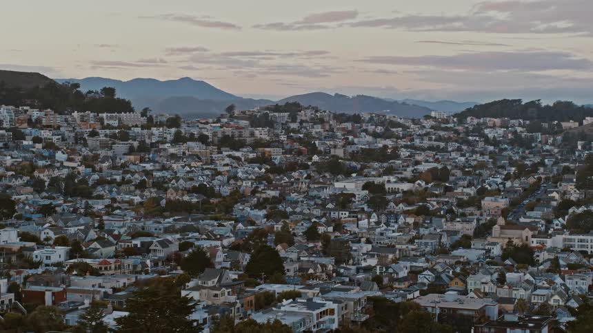 Dense city neighborhoods sit below a mountain range