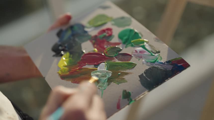 A man mixing paints on a palette