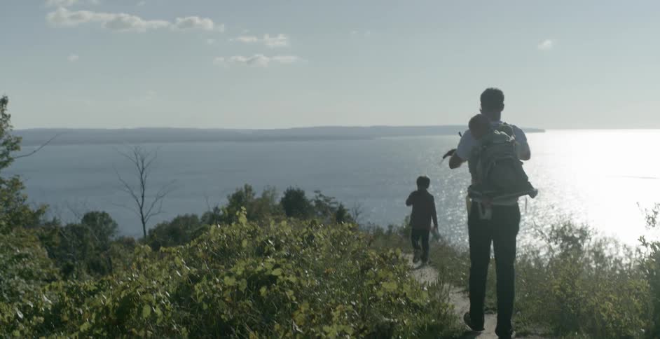 Family walk down a small trail by the water