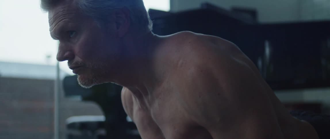 A man pushes himself up while doing yoga at home