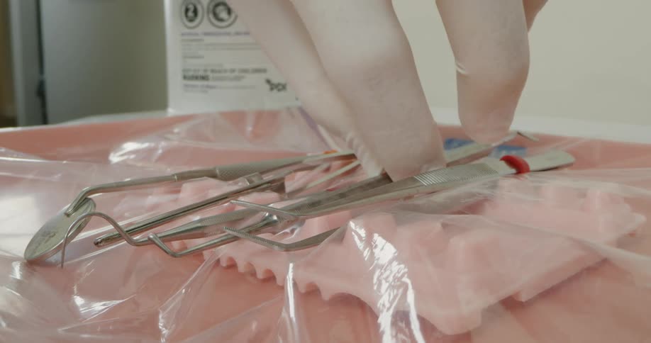 Dentistry professional places dental instrument among other instruments