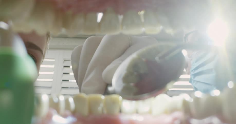 A dentist is working on teeth in someones mouth