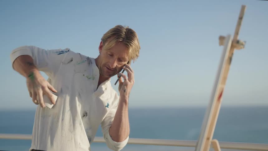 A man is talking on his cellphone and standing outdoors
