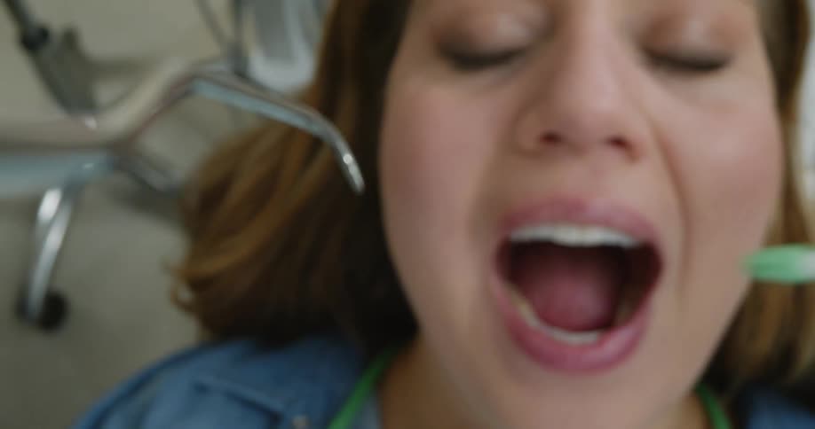 A patient is having their teeth examined at a dentist