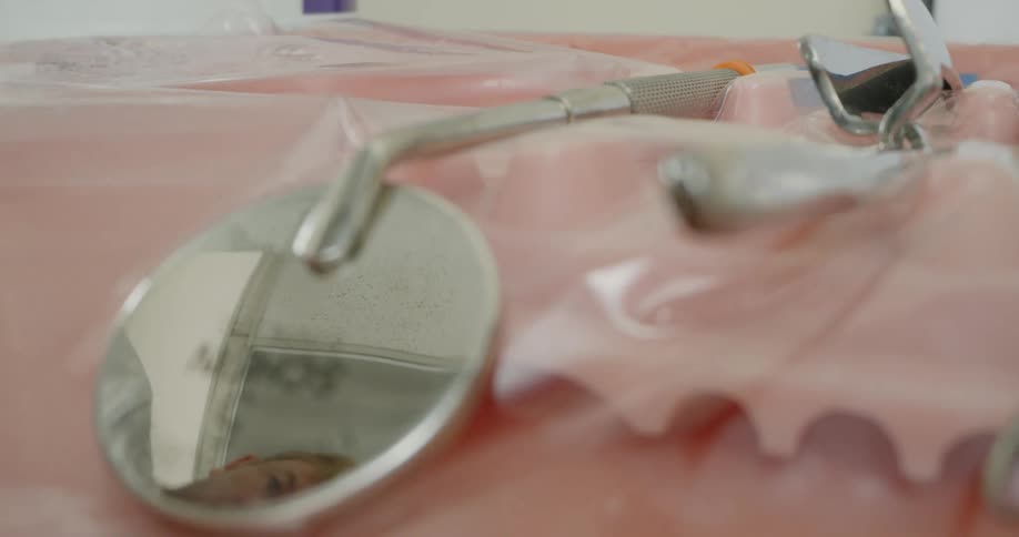 A dentist sets dental equipment down