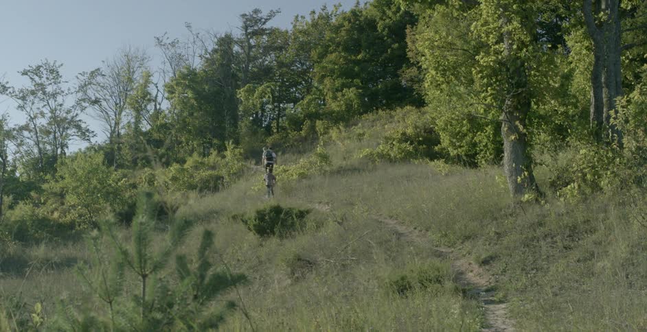 A family hikes up a mountain path in the day