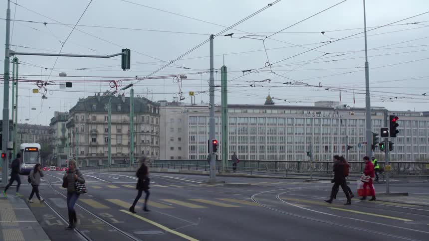 People cross a busy street during the day
