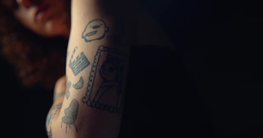 A woman is showing the tattoos on her arm