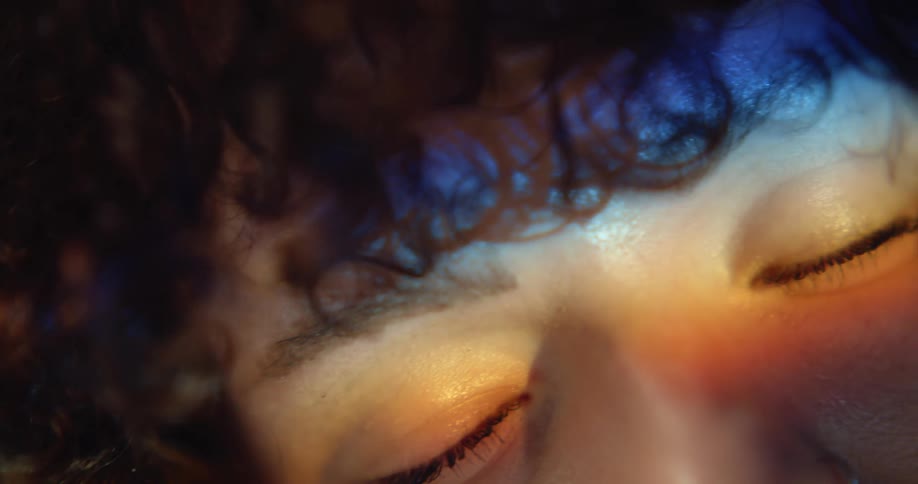 Close up of womans curly hair and with closed eyes