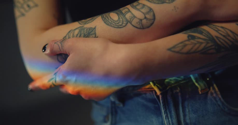 Close up of womans arms with tattoos jeans and black top