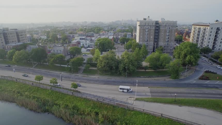 Cars travel down a road near a city