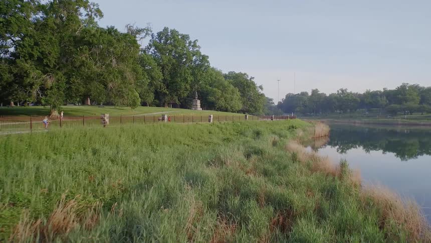 People move along a road by a lake
