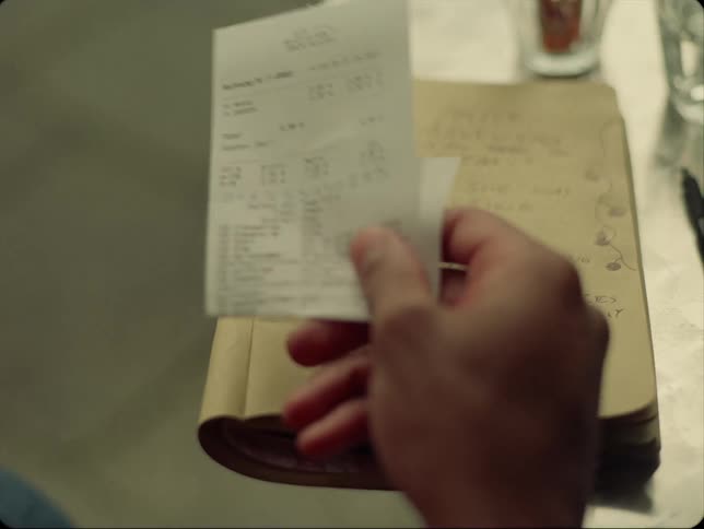 A man picks up a receipt in a restaurant
