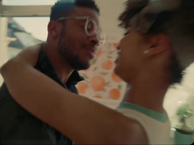 A couple embrace and laugh while dancing in their living room