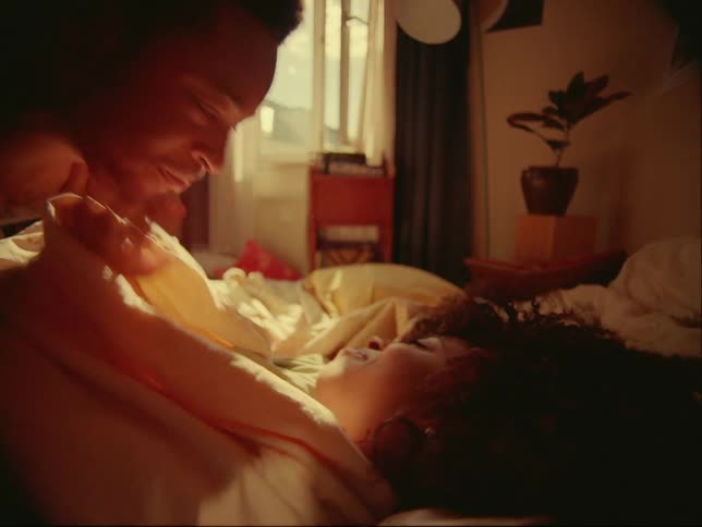 A man and woman hug in bed