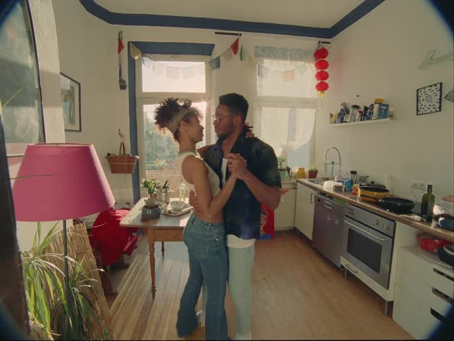 A couple dances with each other inside of a relatively small apartment