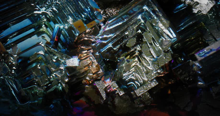 Light shines on the shiny reflective textured surface of an object with many dimensions and a blue highlight