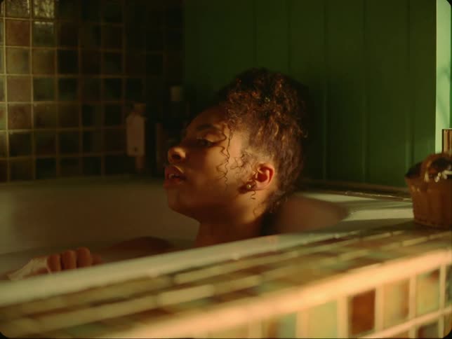 Woman soaks in bathtub with her hair up