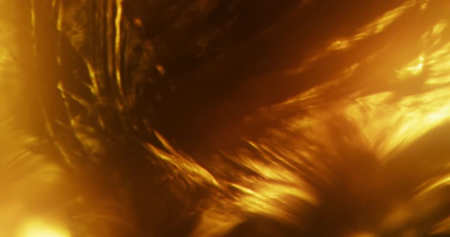 An amber glowing substance illuminates the darkness with bright golden light as it moves