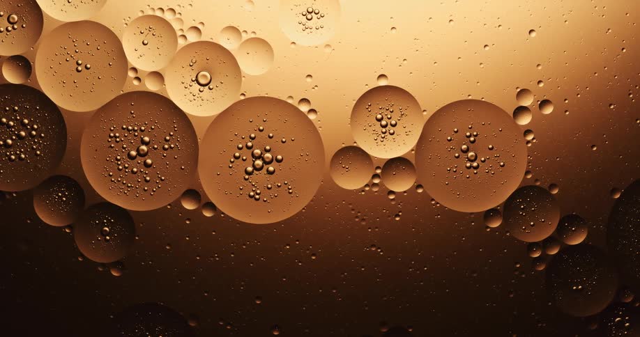 Many spheres are in a golden substance and the bubbles inside of them randomly pop