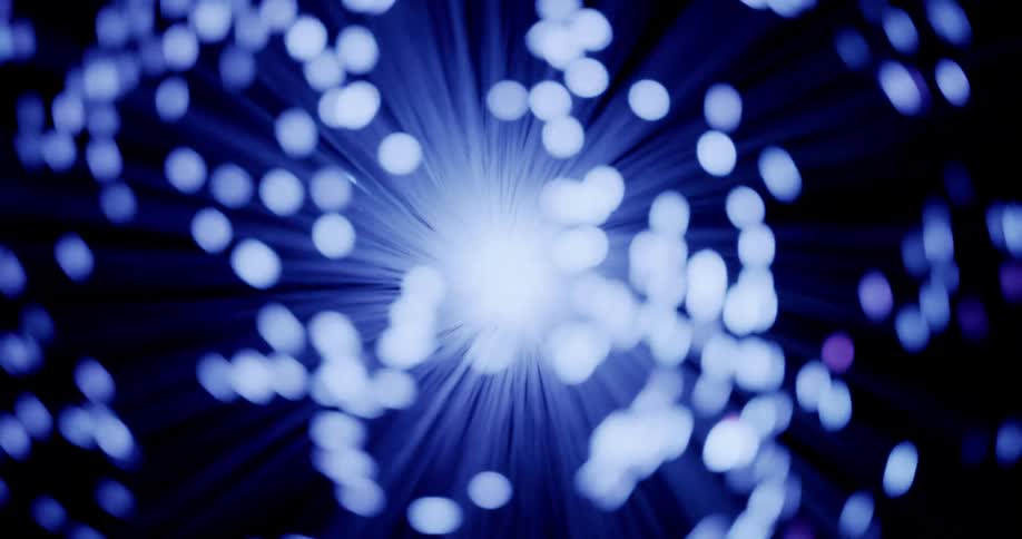 Lights glow on the ends of thin illuminated blue fiber moving in the darkness